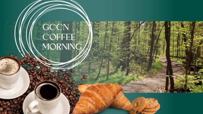 A picture of two cups of coffee, with coffee beans and pastries and a woodland path in the background.
